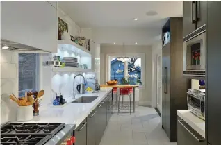  ?? YASMINE GOODWIN PHOTO ?? A kitchen design by Yasmine Goodwin illustrate­s the use of walls to separate spaces, and people, and add lots of storage. The white colour palette lends a clean esthetic.
