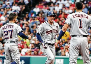  ?? Karen Warren / Houston Chronicle ?? El tercera base Alex Bregman (centro) celebra junto a José Altuve y Carlos Correa tras conectar un jonrón durante el octavo inning del cuarto juego de la serie divisional de la Liga Americana en el Fenway Park.