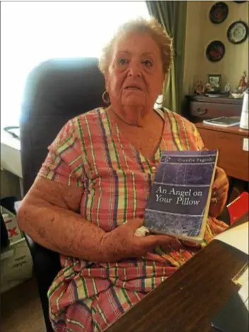  ??  ?? Longtime Clifton Heights resident Claudia Fagioli holds up her book, “An Angel on your Pillow,” the story of her life. From the very beginning she accepted whatever life handed out. She remarks, “There is no need for me to recapture my youth. I had it all and to say otherwise would be an insult to God for these gifts.” PEG DEGRASSA — DIGITAL FIRST MEDIA