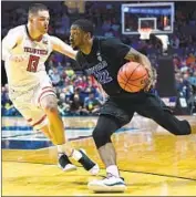  ?? Stacy Revere Getty Images ?? BUFFALO’S Dontay Caruthers drives past Texas Tech’s Matt Mooney during the NCAA tournament.