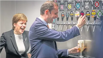  ?? Picture: Mhairi Edwards. ?? First Minister Nicola Sturgeon laughs as North East Fife MP Stephen Gethins pours a glass of beer at St Andrews Brewing Company.