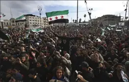  ?? GHAITH ALSAYED — THE ASSOCIATED PRESS ?? Thousands of anti-Syrian government protesters shout slogans and wave revolution­ary flags in Idlib in northwest Syria.