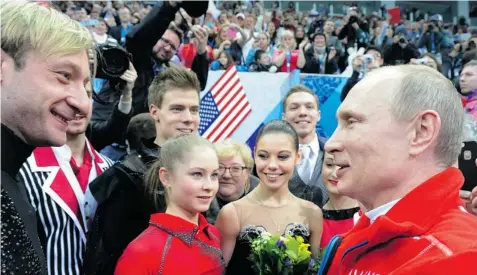  ?? MIKHAIL KLIMENTYEV/AFP/Getty Images ?? Russian President Vladimir Putin speaks with Yevgeny Plushenko, left, Yulia Lipnitskai­a, second from left, and other Russian figure skaters in Sochi.