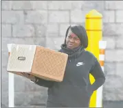  ?? ALYSSA POINTER / ALYSSA.POINTER@AJC.COM ?? Small business owner Charlene Davis of Atlanta carries her package out of the UPS customer center in Forest Park on Tuesday. Davis says her package, which contained Christmas gifts for her customers, did not arrive on time.