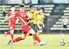  ??  ?? Sabah captain Rawilson Batuil (left) gives Perak’s Ahmad Khairul Anuar Ahmad Zamri little space to attack in their Malaysia Cup semifinals second leg tie at the Likas Stadium last night. - Photo courtesy of Jaiman Taip.