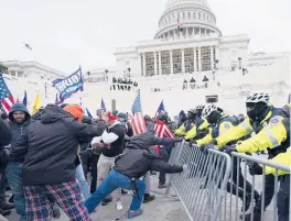  ?? JULIO CORTEZ/AP ?? Supporters of then-President Donald Trump rush forward in a bid to break through a police barrier during a riot Jan. 6 at the U.S. Capitol in Washington.