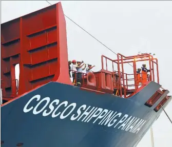  ?? REUTERS ?? Workers are seen on a COSCO container vessel, as it arrives to Cocoli locks after crossing the Panama Canal to the Pacific side.