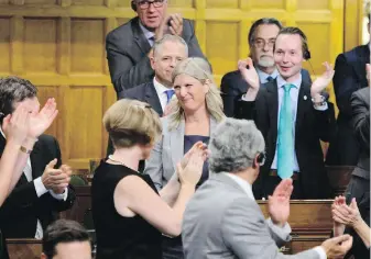  ??  ?? Her new Conservati­ve colleagues applaud Ontario MP Leona Alleslev, centre, Monday in Ottawa.