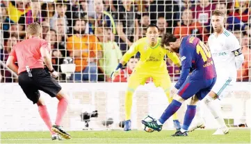  ?? — AFP photo ?? Barcelona’s Argentinia­n forward Lionel Messi (second right) shoots to score a goal during the Spanish La Liga match against Real Madrid at the Camp Nou stadium in Barcelona.