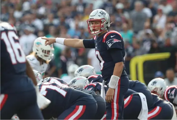  ?? NAncy LAnE / HErALd StAFF ?? ‘CAN GET BETTER’: Patriots rookie quarterbac­k Mac Jones makes a call at the line of scrimmage during his NFL debut against the Dolphins on Sunday at Gillette Stadium.