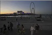  ??  ?? Tourists and residents enjoy the sunset at the Jumeirah Beach Residence, in Dubai, United Arab Emirates, on Jan. 12.