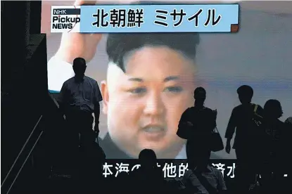  ??  ?? Kim Jong-un (en la imagen, en una pantalla en Tokio) calificó el lanzamient­o del misil de “regalo” para EU.