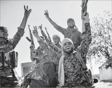  ?? Bulent Kilic AFP/Getty Images ?? MEMBERS of the Syrian Democratic Forces celebrate at the front line in Raqqah on Monday, when Islamic State was on the verge of defeat. On Tuesday, the SDF said it had taken control of the Syrian city.