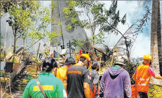  ?? The Associated Press ?? In this photo released by the Joint Task Force-sulu, rescuers search for bodies Sunday on the site where a Philippine military C-130 plane crashed in Patikul town, Sulu province, southern Philippine­s. The crash killed at least 42 army soldiers.