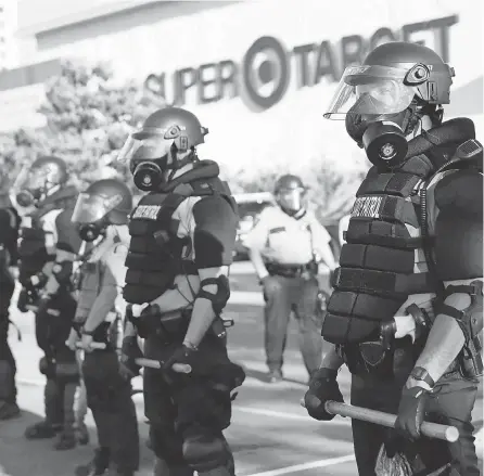  ??  ?? Minnesota State Police assemble in front of a Target Store in St. Paul, Minn., late last month. JOHN MINCHILLO/ AP