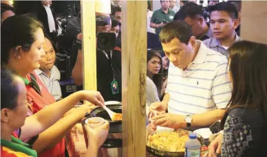  ??  ?? LONG-TIME CUSTOMER – President Rodrigo Duterte tries the Chili Con Carne of one of his favorite restaurant­s Aling Foping's during the launch of Kaon Ta, a food and travel festival, at Abreeza Mall in Davao City on Friday. (Keith Bacongco)