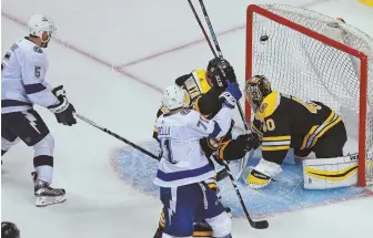  ?? STaff phoTos by MaTT WEsT ?? ZAPPED: The Lightning’s Dan Girardi tips home a shot in overtime to hand the Bruins a 4-3 defeat in last night’s Game 4 at the Garden; below, Brian Gionta (12) and Tuukka Rask skate off the ice after the defeat as the Bruins now trail in the series,...