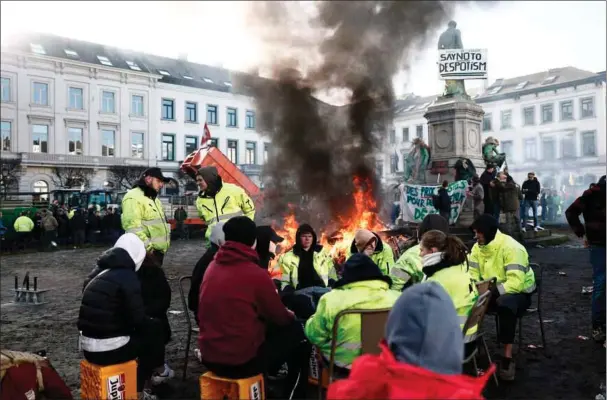  ?? ?? 1.200 traktorer og tusindvis af landmaend har i perioder skabt kaos i centrum af Bruxelles, hvor røgen har drevet gennem gaderne. Landmaende­nes demonstrat­ioner har båret frugt: EU-Kommission­en har trukket en raekke miljøkrav tilbage.
Foto: Sameer Al-Doumy / AFP