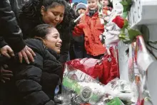  ?? Nam Y. Huh / Associated Press ?? One of shooting victim Vicente Juarez’s daughters, Diana Juarez, cries at a makeshift memorial Sunday in Aurora, Ill.