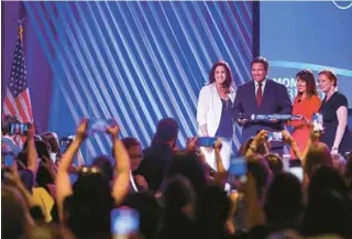 ?? LAUREN WITTE/TNS ?? Gov. Ron DeSantis is presented with “The Liberty Sword” during the Moms for Liberty National Summit on Friday in Tampa.