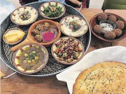  ??  ?? Top left: Nanaz Mezze with, clockwise from top, tabbouleh, baba ghanoush, eggplant salad, ful, halloumi and hummus. In the centre, cauliflowe­r fritters with beet-sour cream dip. Top right: Falafel with tahini dip. Bottom right: Flatbread with sesame and nigella seeds.