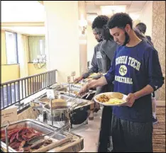  ?? PHOTOS BY KEN SUGIURA / KSUGIURA@AJC.COM ?? Above: Tech guard Josh Heath and teammates go through the breakfast buffet line Saturday at the team’s hotel in Winston-Salem, N.C.