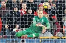  ??  ?? Karius bounces back from the blow by saving Kane’s first penalty attempt