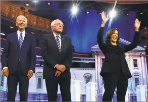  ?? Brynn Anderson / Associated Press ?? Democratic presidenti­al candidates former vice president Joe Biden, left, Sen. Bernie Sanders, IVt., and Sen. Kamala Harris, DCalif., right, stand on stage for a photo op before the start of the the Democratic primary debate hosted by NBC News at the Adrienne Arsht Center for the Performing Arts in Miami on June 27.