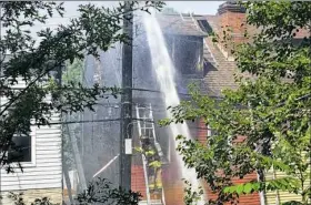  ??  ?? Firefighte­rs battle a four-alarm house fire that killed two children Monday along Sorrell Street in Marshall-Shadeland.