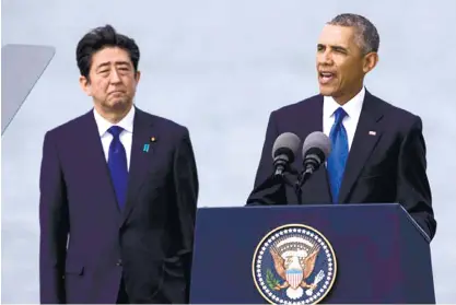  ?? (AP FOTO) ?? ‘HISTORIC’ GESTURE. U.S. President Barack Obama (right), with Japanese Prime Minister Shinzo Abe, speaks at Joint Base Pearl Harbor Hickam in Honolulu. Abe and Obama made a historic pilgrimage on Tuesday to the site where the devastatin­g surprise...