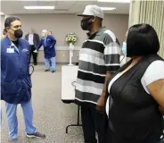  ?? (Pine Bluff Commercial/ Eplunus Colvin) ?? Dr. Ali Alnashif (left), the lead physician who helped treat James Black (center) last year at Jefferson Regional Medical Center, visits with Black and his wife, Shaunika.