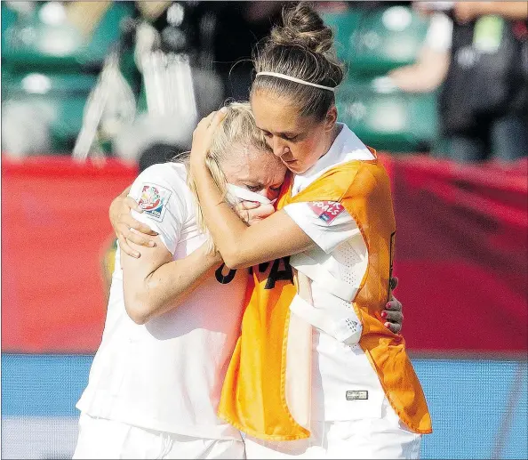  ?? — THE CANADIAN PRESS ?? Josanne Potter, right, consoles Laura Bassett after England lost 2-1 to Japan in a Women’s World Cup semifinal game Wednesday night in Edmonton. Bassett scored on her own goal late in the game while trying to break up a Japanese passing play.