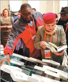  ?? FENG YONGBIN CHINA DAILY ?? Delegates at a high-level meeting at the Great Hall of the People in Beijing on Friday read during a break the second volume of Xi Jinping: The Governance of China, a book that proved popular at the meeting.