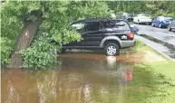  ?? ERIC ASPENSON / MILWAUKEE JOURNAL SENTINEL ?? A car is parked this week in floodwater­s near the Milwaukee River on Shoreland Parkway in Mequon.