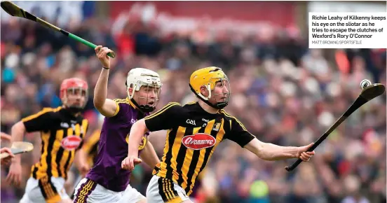  ?? MATT BROWNE/SPORTSFILE ?? Richie Leahy of Kilkenny keeps his eye on the sliotar as he tries to escape the clutches of Wexford’s Rory O’Connor