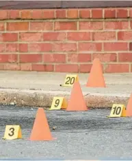  ?? JULIO CORTEZ/AP ?? Evidence markers at the site of a shooting near EdmondsonW­estside High School on Jan. 4 in Baltimore. Police claim five boys, believed to be high school students on their lunch break, were shot at a shopping center; one has died.