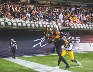  ?? The Canadian Press ?? B.C. Lions receiver Bryan Burnham (16) keeps his foot in bounds to score the tying two-point conversion as Hamilton Tiger-Cats’ Cariel Brooks (26) defends during CFL action in Vancouver last Saturday. The Lions won 35-32 in double overtime, but the Ticats will be looking to avenge that loss during today’s rematch in Hamilton. Kickoff is set for 1 p.m. PT.