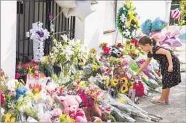  ?? Richard Ellis
European Pressphoto Agency ?? CHARLESTON, S.C.: A girl leaves f lowers at a memorial outside Emanuel AME Church, where nine people were killed Wednesday during Bible study.