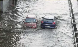  ?? — PTI ?? Vehicles wade through a waterlogge­d Delhi-Gurgaon Expressway service road after heavy rains at Narsinghpu­r in Gurgaon on Sunday.