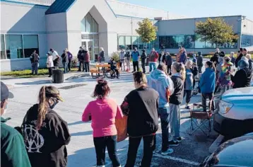  ?? KAITI SULLIVAN/THE NEW YORK TIMES ?? People line up outside the Gleaners Food Bank in Indianapol­is on Oct. 20.