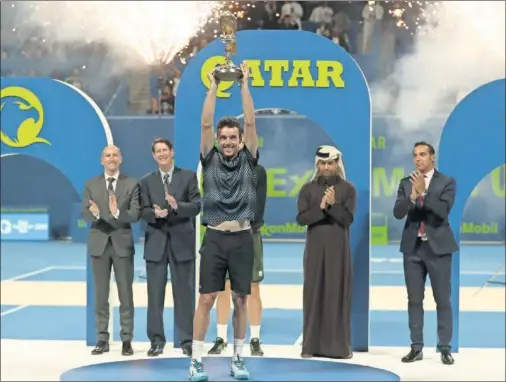  ??  ?? TRIUNFADOR. Roberto Bautista levanta eufórico el trofeo que le acredita como ganador del ATP 250 de Doha, un halcón dorado.