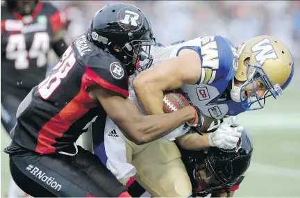  ?? JULIE OLIVER ?? Ottawa’s Corey Tindal tackles Winnipeg’s Julian Feoli-Gudino during first-half action at TD Place on Friday night.