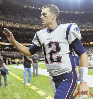  ?? STaff phoTo by chrisTophe­r evans ?? GIVE HIM A HAND: Tom Brady heads off the field after the Pats’ big win over the Saints yesterday in New Orleans.