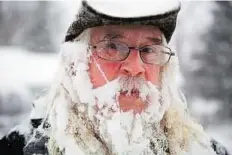  ??  ?? Unaware of icicles Lee Tuttle, 66, takes a break from blowing snow off his driveway at his home on Miller Road in Flint, Michigan.
AP