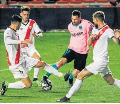  ??  ?? Messi trata de salir del regate ante tres jugadores del Rayo Vallecano.