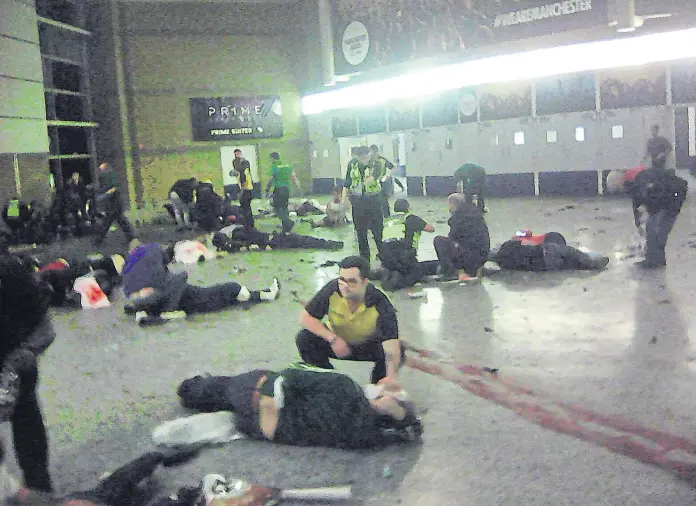  ?? AP ?? Socorrista­s y voluntario­s asisten a los heridos del atentado del Manchester Arena, anteanoche, en el hall de entrada del estadio