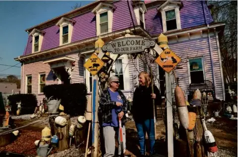  ?? ?? Audrey Agli (left) and Liz Smith’s yard in front of their purple house is filled with buoys. “Sometimes people leave buoys in the driveway with notes, ‘You need these more than me,’” said Angli, who loves the sea.