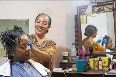  ?? ALYSSA POINTER / ALYSSA.POINTER@AJC.COM ?? Hairstylis­t Erica Blevins (right) retwists Gwendolyn Pilot’s locs at the Oh My Nappy Hair salon in downtown Atlanta. A recent study found that black women are more likely to be exposed to dangerous chemicals in the hair care products they use.