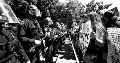  ?? Nelvin C. Cepeda/The San Diego Union-Tribune via AP ?? In this June 6 file photo, protestors are met with a police line on the corner of 14th Street and Broadway, preventing them from approachin­g any closer to the San Diego Police Department, SDPD headquarte­rs downtown San Diego.