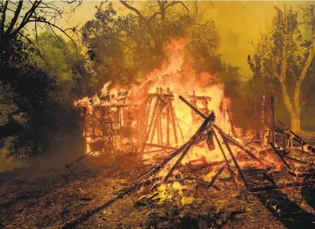  ?? Noah Berger / Associated Press ?? Flames from the Quail Fire, which started in Solano County, consume an outbuildin­g near Winters (Yolo County).